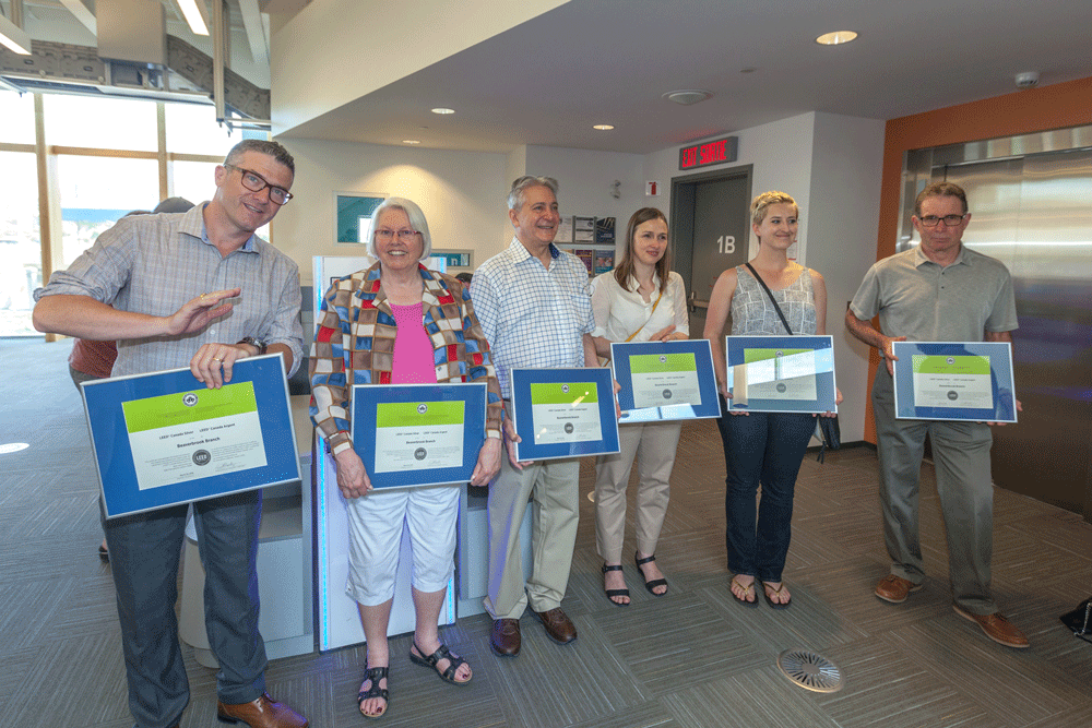 A group of staff and board members holding framed certificates