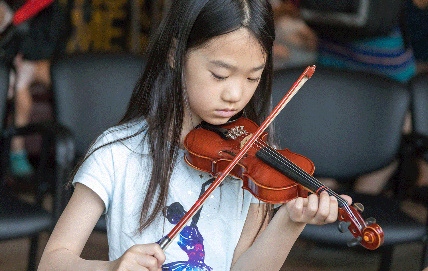 A young girl playing a violin